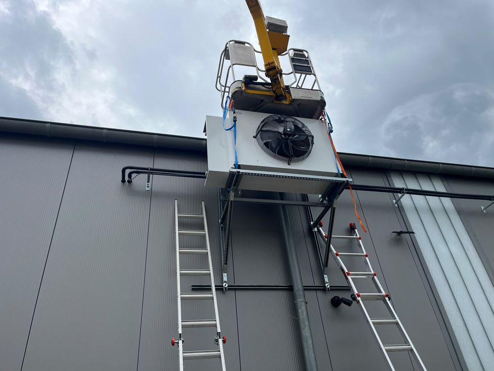 Condenser unit being lifted onto a facade