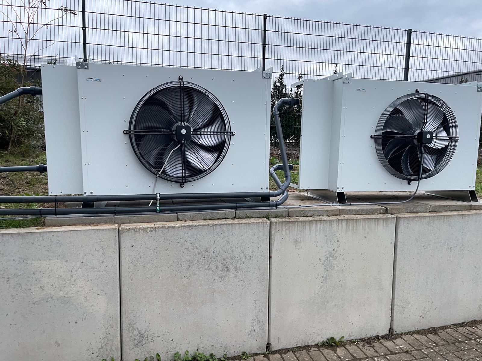 Two outdoor condenser units on a concrete base